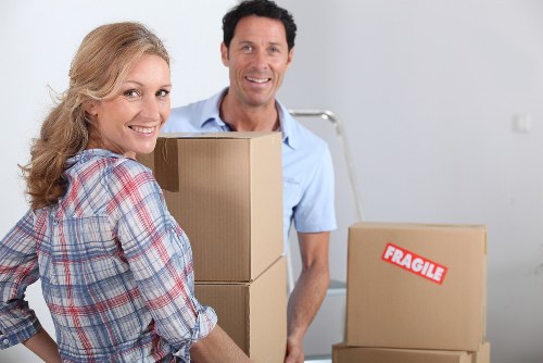 Moving team handling boxes and furniture in a South Hornchurch home